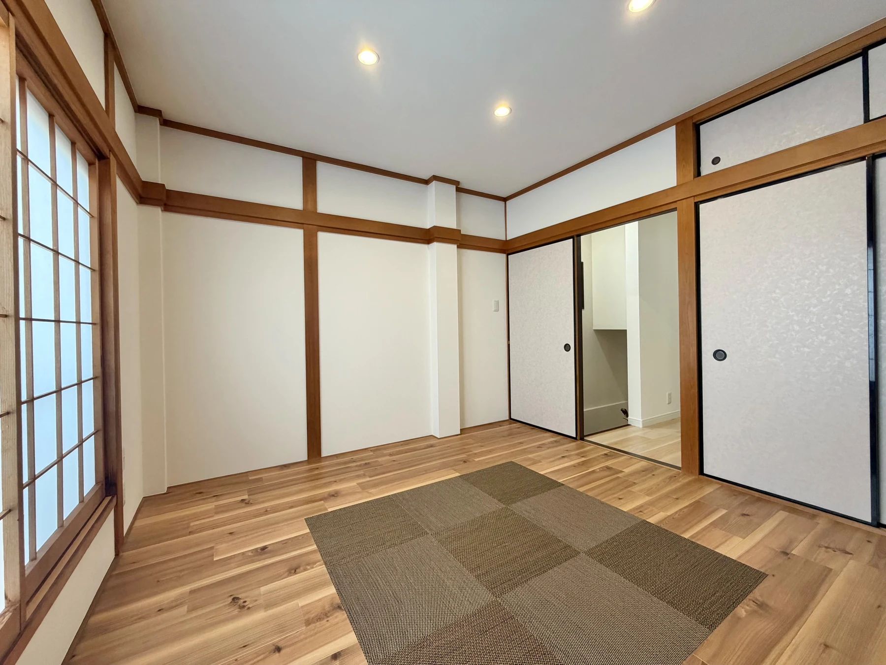 南田辺の住まい・施工後：木目の床と置き畳、白い天井を組み合わせた一室。
