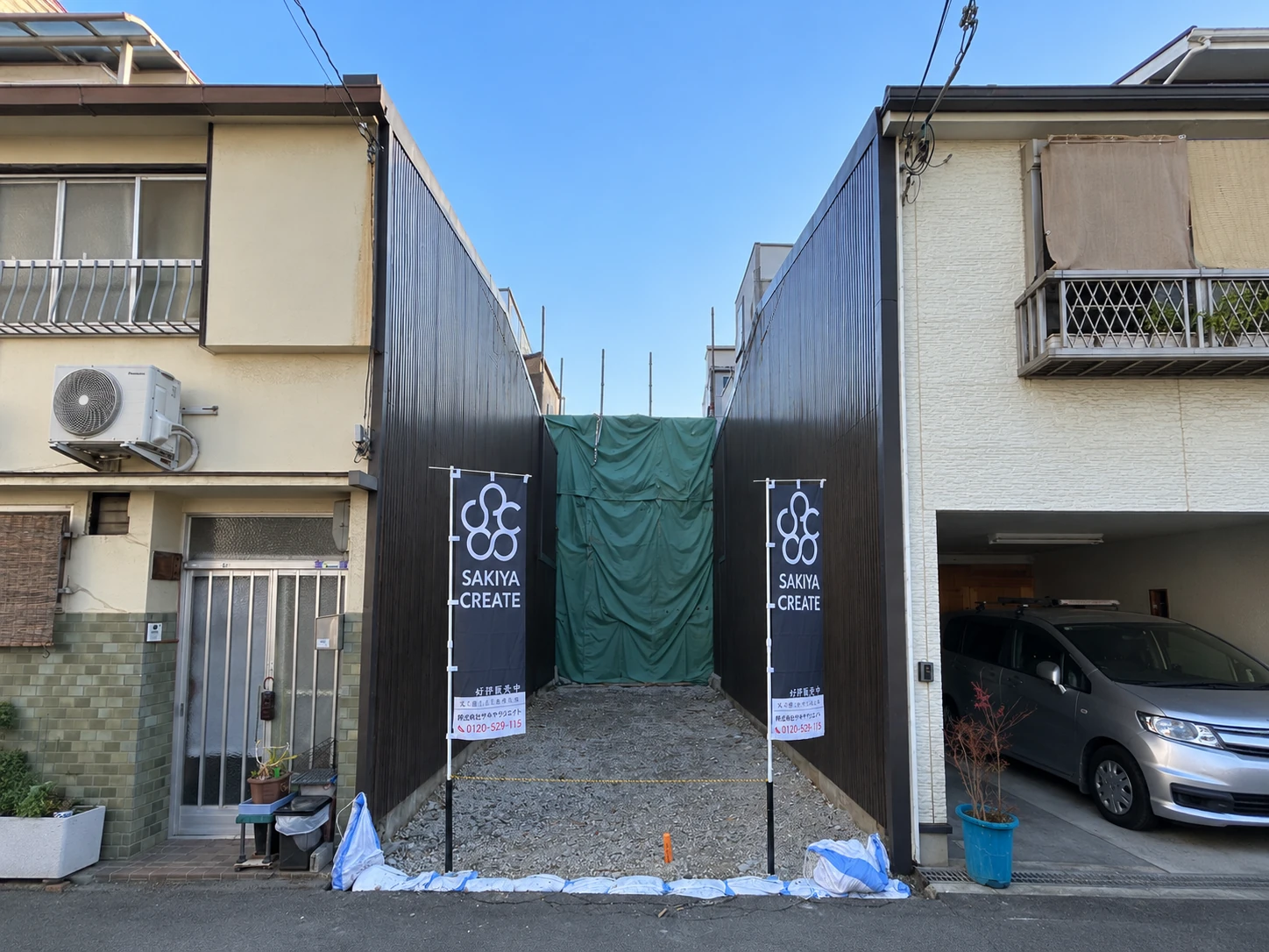隣り合う住宅の間にある大開2丁目の敷地と、サキヤクリエイトののぼり